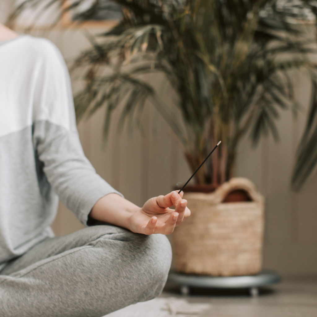 Mujer en posición de meditación con las manos apoyadas sobre las rodillas, representando el poder de los mantras y la calma interior.