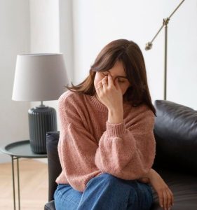 Mujer pensativa sentada en un sillón, simbolizando la resistencia y el proceso de reflexión antes de iniciar terapia