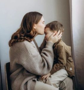 Madre abrazando y protegiendo a su hijo pequeño en un gesto de cuidado y seguridad emocional relacionado al abuso sexual infantil